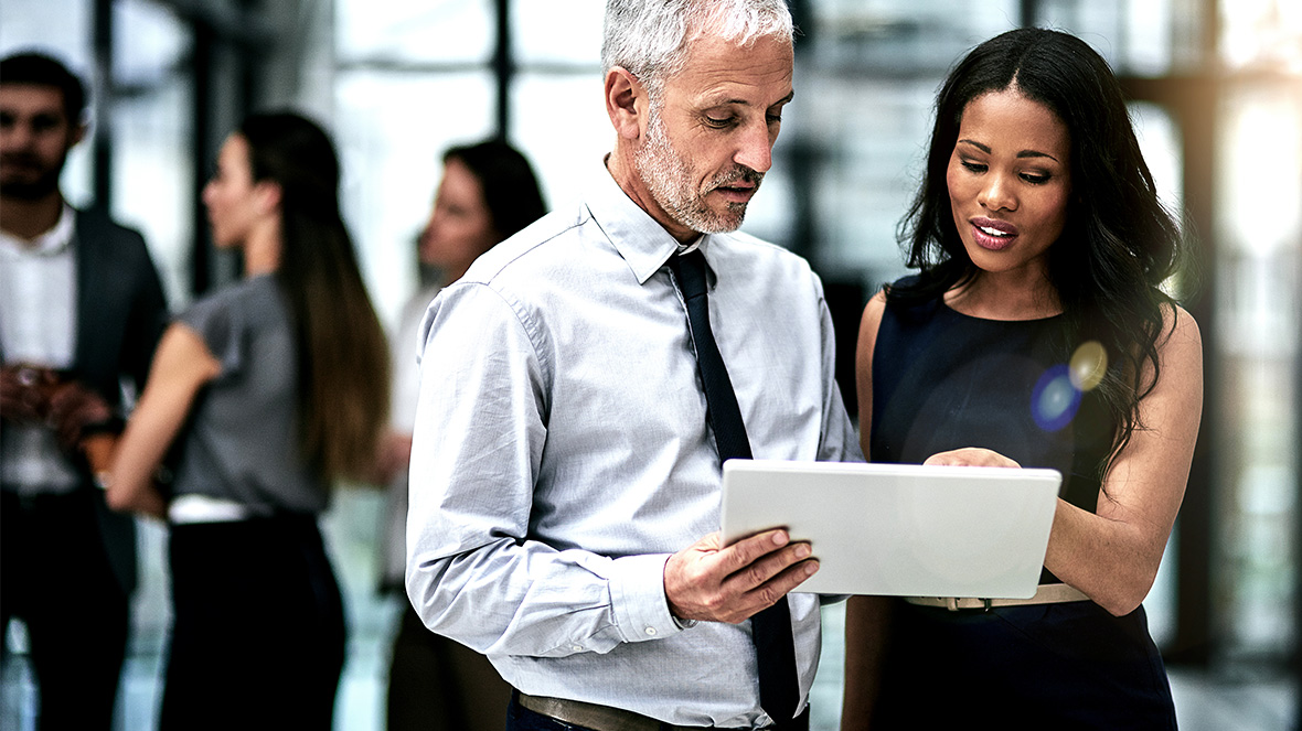 Dois colegas olhando para uma tela portátil