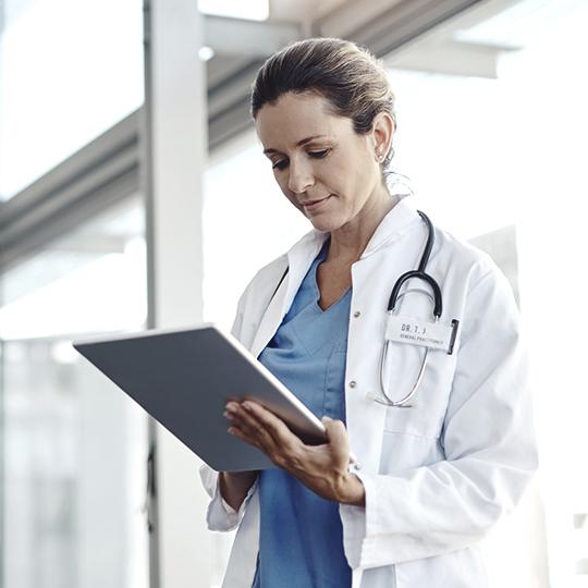 DMConnect - fluxos de trabalho profissionais em suas impressões digitais Female doctor looking at laptop
