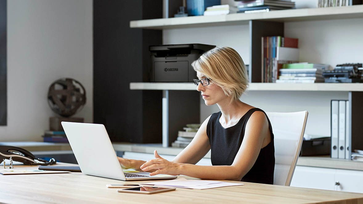 woman sitting at a desk with a laptop woman sitting at a desk with a laptop