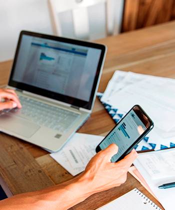  mãos com computador e telefone